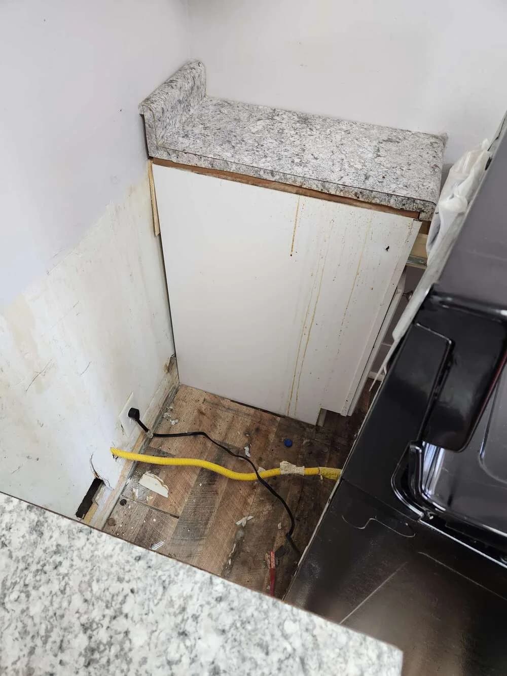 Kitchen mid-renovation being cleaned down to the studs and stone
