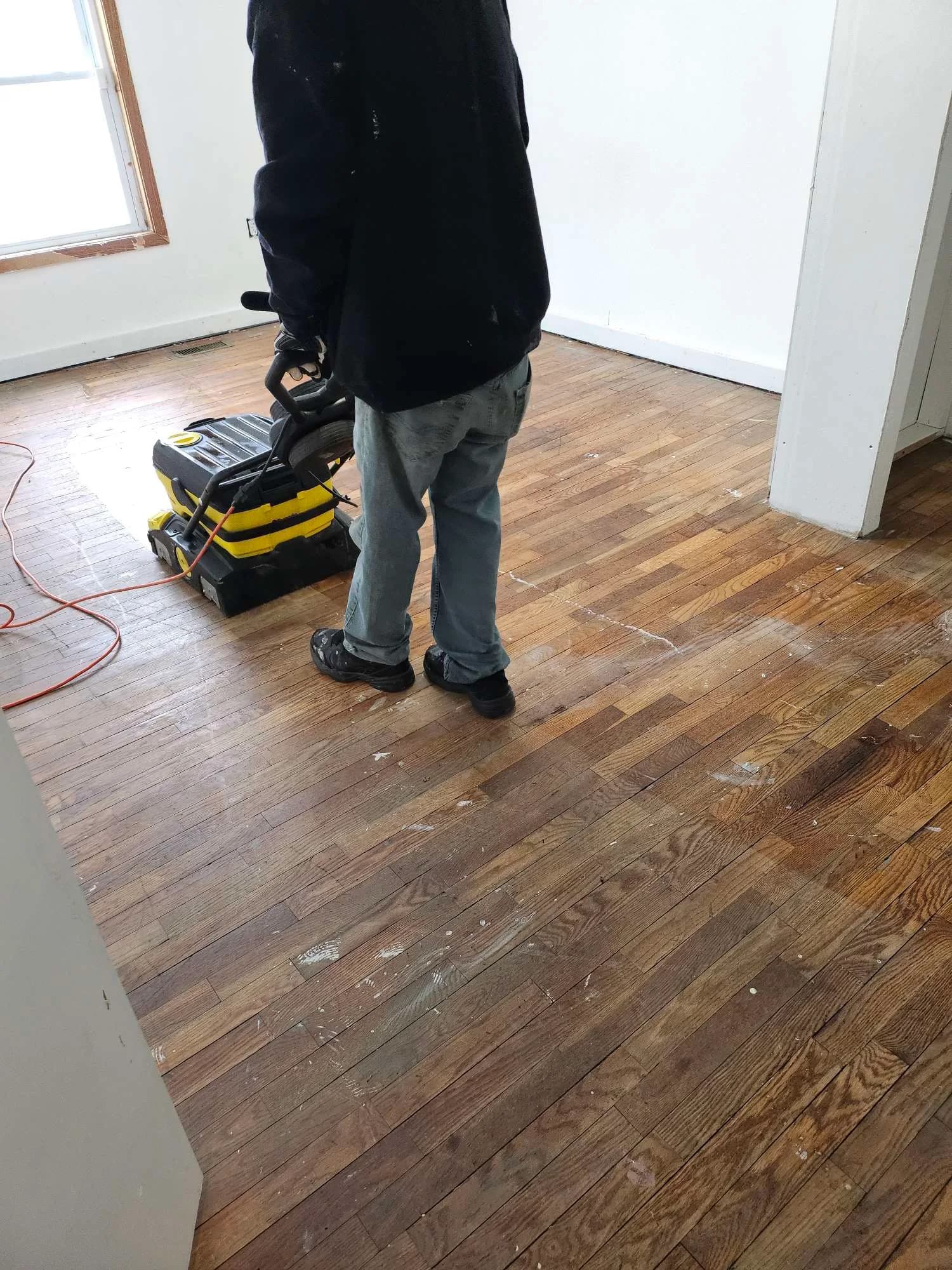 Orbital floor machine working a wood floor back to level sheen
