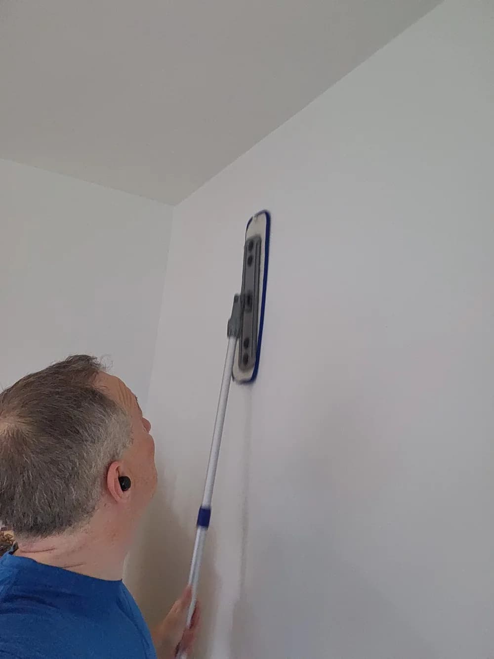 Technician working a wall from ceiling to floor during a whole-home deep clean