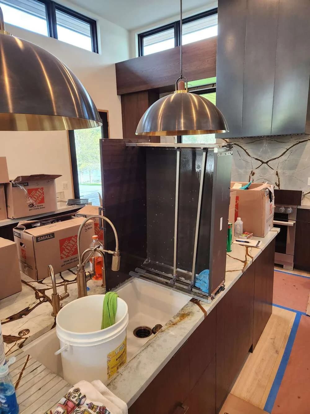 Commercial kitchen line mid-deep-clean, equipment pulled and surfaces degreased